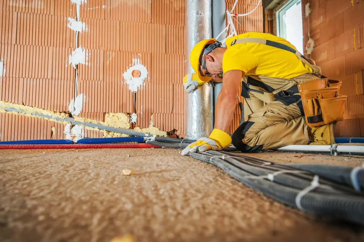 electrical contractor laying wiring on ground