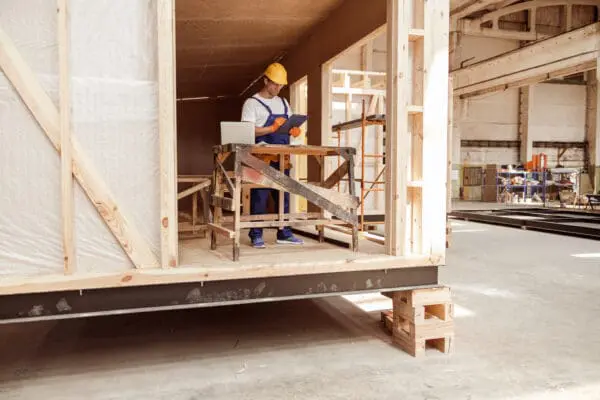 Builder writing on clipboard on safe construction site